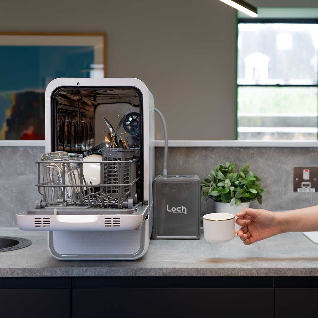 A compact countertop dishwasher with its door open, showcasing a modern design and space-saving features for smaller kitchens